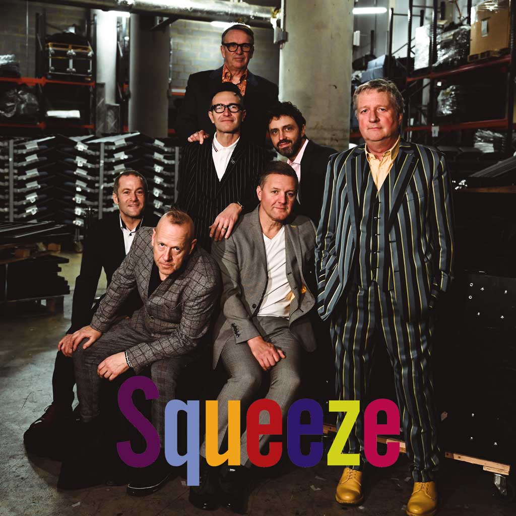 The members of squeeze pose for a photo backstage at a gig