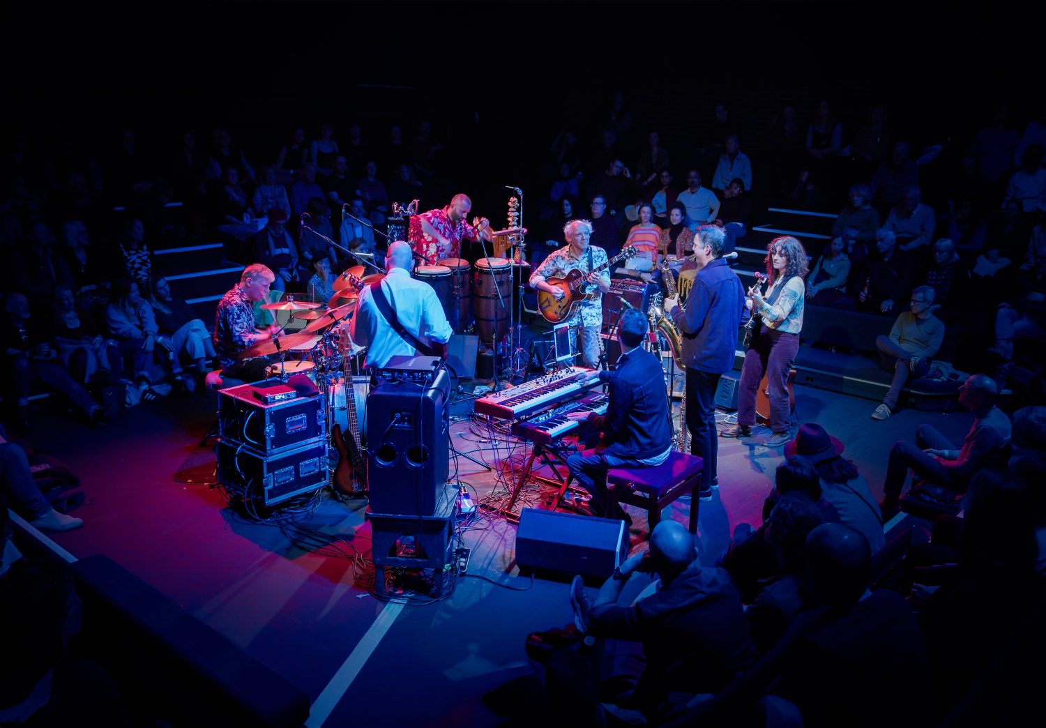 An image of the band hejira performing together on a stage in dim lighting